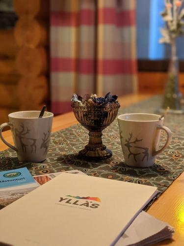 two coffee cups and a bowl on a table at Tunturioravat in Äkäslompolo