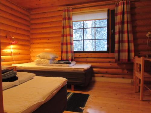 a bedroom with two beds in a log cabin at Tunturioravat in Äkäslompolo