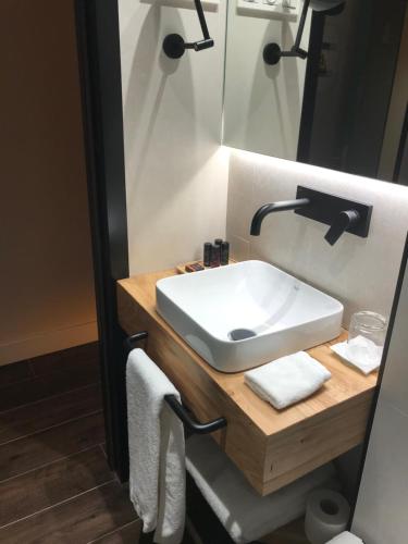 a bathroom with a white sink and a mirror at Camarote Hotel in León
