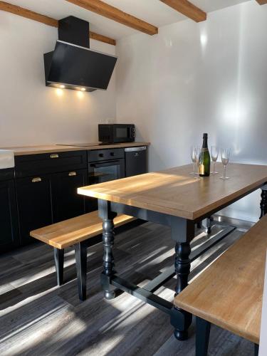 une cuisine avec une table en bois et deux bancs dans l'établissement Gîte Magnolia Châtenois ALSACE, à Châtenois