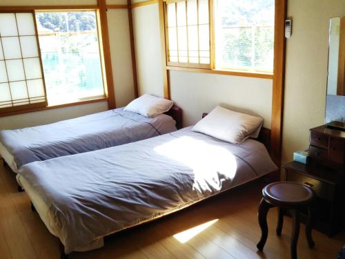 two beds in a room with two windows at Pension Rally / Vacation STAY 5731 in Kawazu
