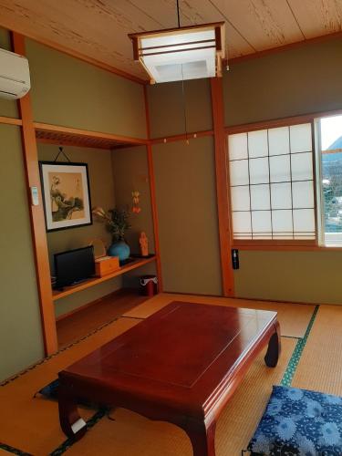 sala de estar con mesa y TV en Pension Rally / Vacation STAY 5731, en Kawazu