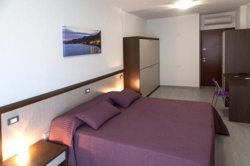 sypialnia z dużym łóżkiem z fioletową pościelą w obiekcie Locanda Brezza Marina camera quadrupla w mieście Finale Ligure