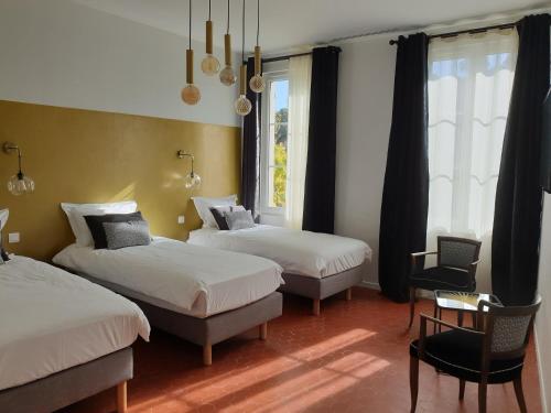 1 Schlafzimmer mit 2 Betten, einem Stuhl und einem Fenster in der Unterkunft Le Clos Marceau in Bédoin