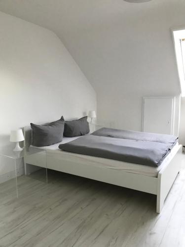 biała sypialnia z dużym łóżkiem w pokoju w obiekcie City Flat gegenüber Kurhaus, Zentrum Freudenstadt w mieście Freudenstadt