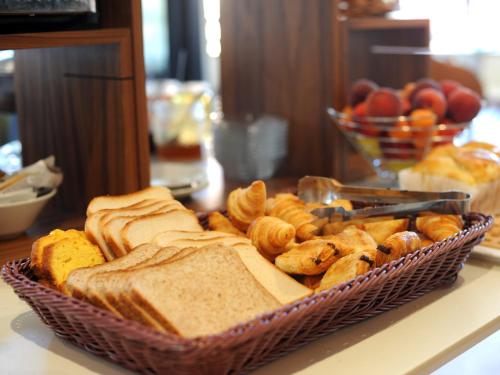 a basket of bread and pastries on a table at Logis Hôtel du Haut-Bugey in Oyonnax