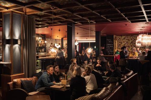 un grupo de personas sentadas en mesas en un restaurante en Kurhaus Lenzerheide, en Lenzerheide