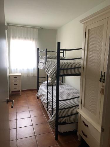 two bunk beds in a room with a window at Lirio in L'Ampolla