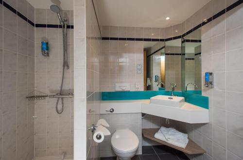 a bathroom with a toilet, sink, and shower at Holiday Inn Express London - Dartford, an IHG Hotel in Dartford