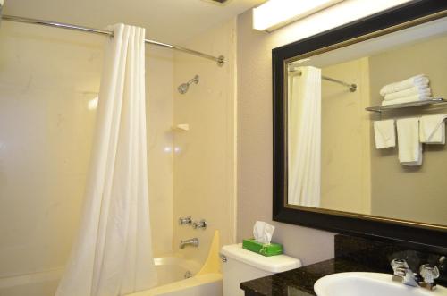 a bathroom with a shower and a sink and a toilet at Super 8 by Wyndham Bentonville in Bentonville