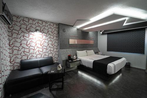 a bedroom with a bed and a couch in it at Kuboz Motor Hotel (Motel y Hotel) in Guadalajara