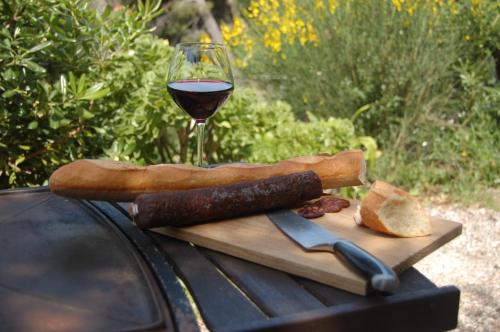 a glass of wine and a cutting board with bread and a knife at Magnifique "Gite de la Garoupe" au Cap d'Antibes à 300m des plages in Antibes