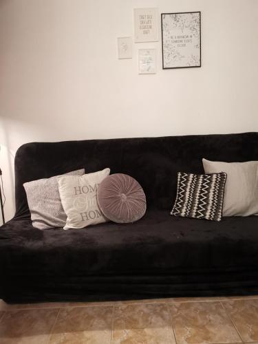 a black couch with several pillows on it at Apartmani "Mary" in Grebaštica