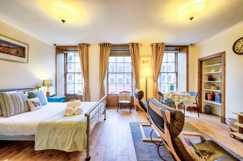 a bedroom with a bed and a table and chairs at JOIVY Royal Mile Apartment for Two - Location, Location! in Edinburgh
