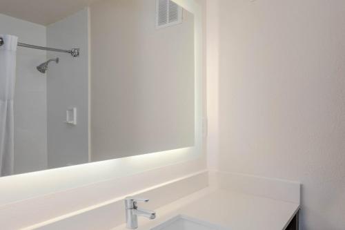 a white bathroom with a sink and a mirror at Wyndham Garden Tallahassee Capitol Near FSU in Tallahassee