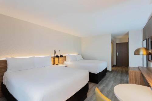 a hotel room with two beds and a table at Wyndham Garden Tallahassee Capitol Near FSU in Tallahassee