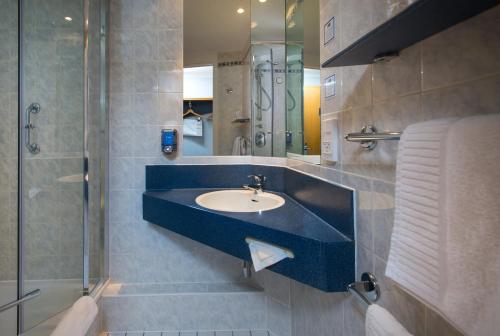 y baño con lavabo y ducha. en Holiday Inn Express Manchester - Salford Quays, an IHG Hotel en Mánchester