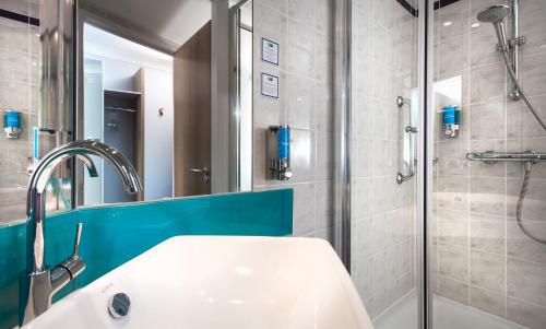 
a bathroom with a shower, sink, and mirror at Holiday Inn Express - Glasgow Airport, an IHG Hotel in Paisley
