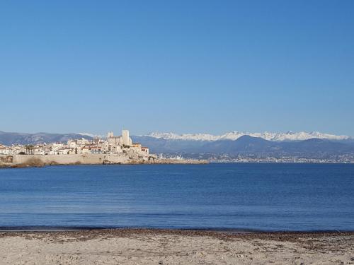 a large body of water with a city in the background at Magnifique "Gite de la Garoupe" au Cap d'Antibes à 300m des plages in Antibes
