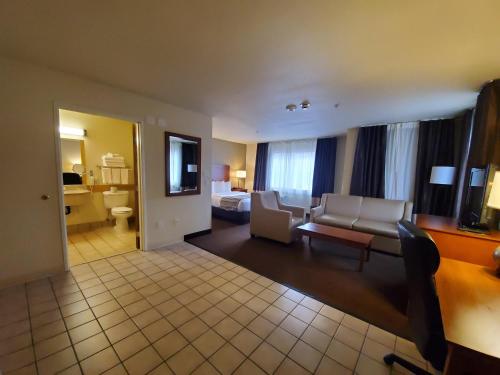 a living room with a couch and a bed in a hotel room at Country Inn & Suites by Radisson, Bend, OR in Bend
