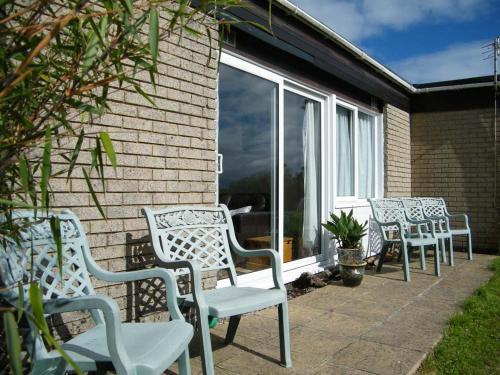 a group of white chairs sitting on a patio at Chalet at Penstowe Holiday Park Near Bude in Bude