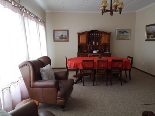 a dining room with a red table and chairs at DKC Accommodation in Sutherland