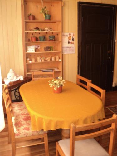 a dining room table with a yellow table and chairs at La Casona del Buen dormir in Valdivia