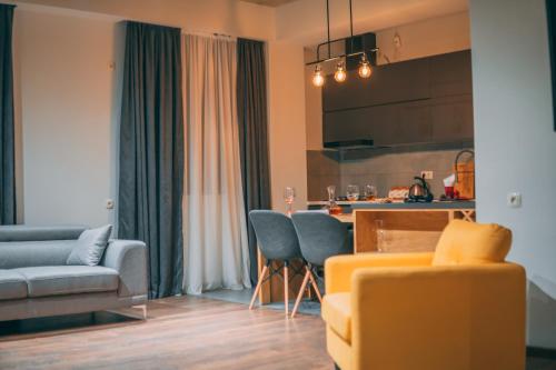a living room with a yellow couch and a kitchen at APARTMENT SIXTEEN in Tbilisi City
