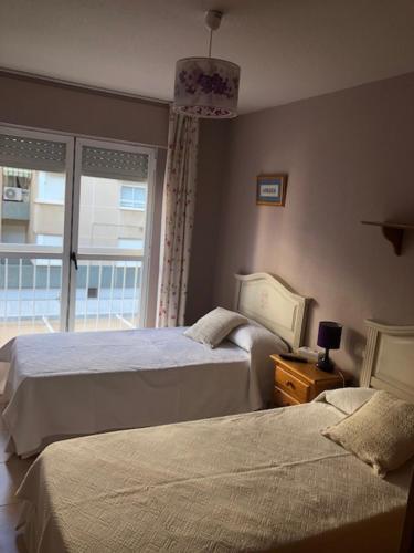 a bedroom with two beds and a window at Apartamento las Yucas - Aguilas in Águilas