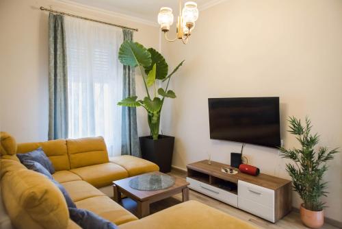 a living room with a couch and a flat screen tv at Villa Apartman in Makó