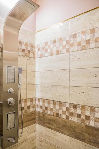a shower stall in a bathroom with tiles at Villa Apartman in Makó