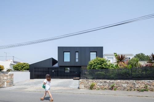 La Maison De La Rade في Le Relecq-Kerhuon: A young girl walking down the street in front of a house