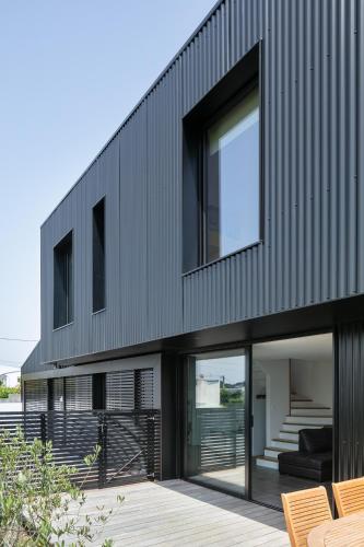 une maison moderne avec une façade noire dans l'établissement La Maison De La Rade, à Le Relecq-Kerhuon