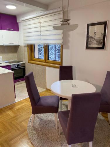 Una cocina y un comedor con mesa y sillas. en Sani, en Zlatibor