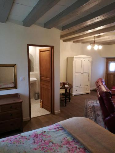 1 dormitorio con cama, mesa y espejo en Chez Pastuso, en Brigueuil-le-Chantre