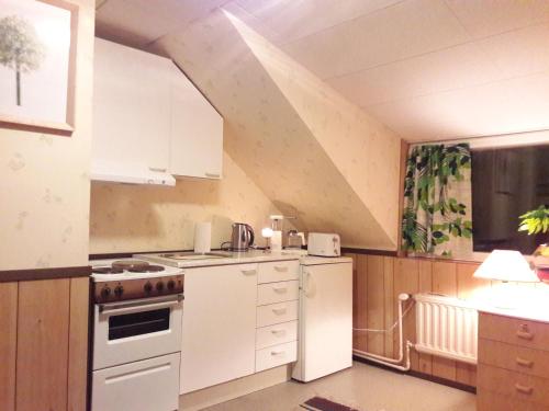 uma cozinha com armários brancos e um frigorífico branco em Huoneisto omenapuiden katveessa em Kankaanpää