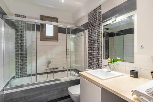 a bathroom with a tub and a sink and a toilet at PANORAMA APARTMENT in Apolpaina