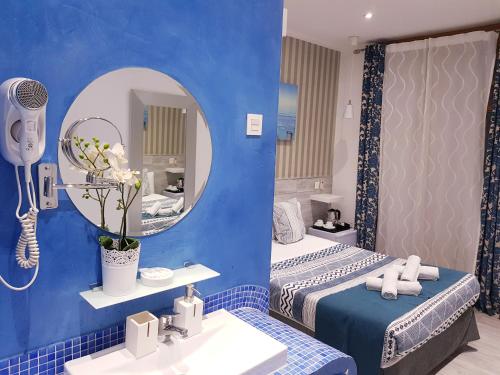 baño con 2 camas, espejo y lavamanos en Hostal Main Street Madrid en Madrid