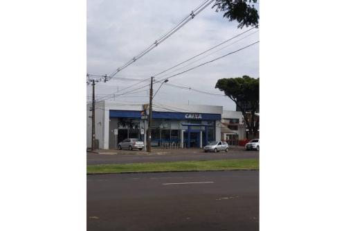 a building on the corner of a street with a car dealership at Apartamento Cidade Verde 6 MT in Maringá