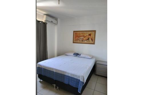 een slaapkamer met een bed en een foto aan de muur bij Apartamento Cidade Verde 6 MT in Maringá