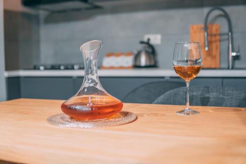 a glass vase and a glass of wine on a table at APARTMENT SIXTEEN in Tbilisi City