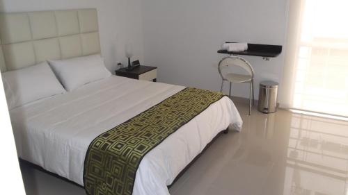 a bedroom with a bed and a chair in it at Hotel Ipanema Meridian in Neiva
