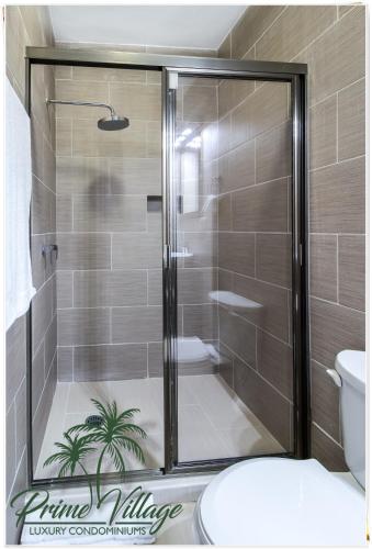 a shower with a glass door in a bathroom at PRIME VILLAGE Cozumel in Cozumel