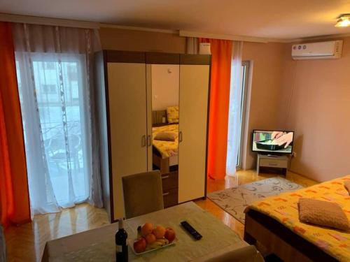 a bedroom with a mirror and a table with fruit on it at Apartmani Mićić in Vrnjačka Banja