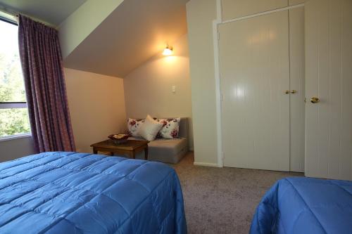 a bedroom with a bed and a couch and a window at Star Dream Manor in Lake Tekapo