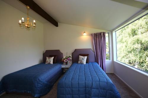 two beds sitting in a room with a window at Star Dream Manor in Lake Tekapo