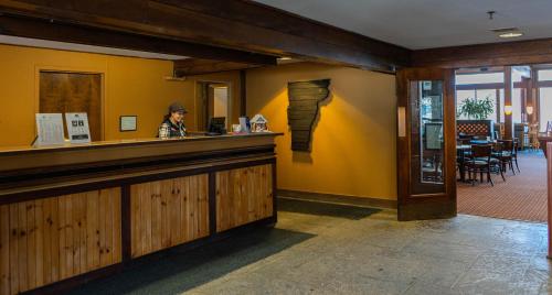 a woman sitting at a bar in a restaurant at The Black Bear Lodge at Stratton Mountain Resort in Stratton Mountain