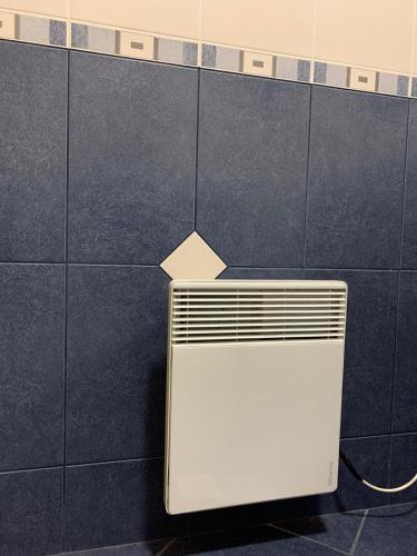 a white radiator on a blue tiled wall at Apartmani Mićić in Vrnjačka Banja