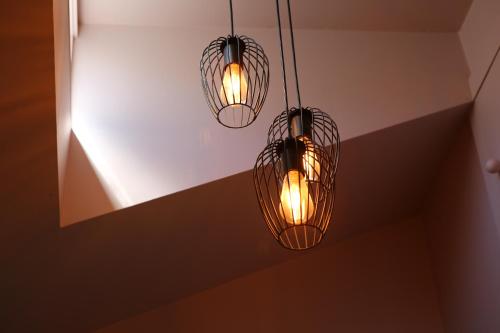 three lights hanging from a ceiling in a room at Star Dream Manor in Lake Tekapo