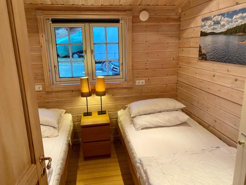 um quarto com duas camas e uma janela em Ferienhaus Stenbäcken in Mittelschweden em Töcksfors
